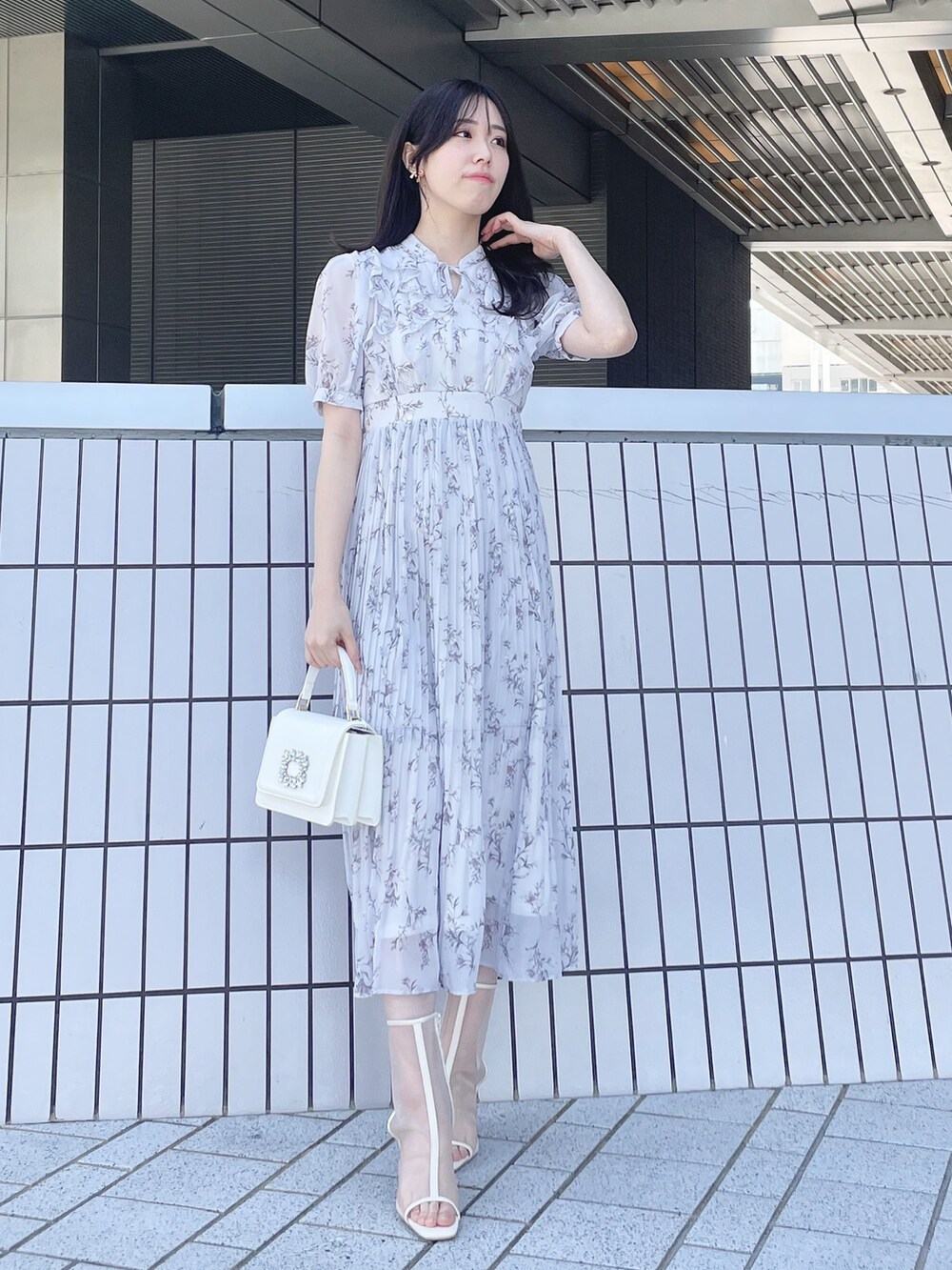 ホワイト系のトレンチコート、グレー系のワンピース、ホワイト系のブーツを着用したレディースの春コーディネートの5枚目の写真