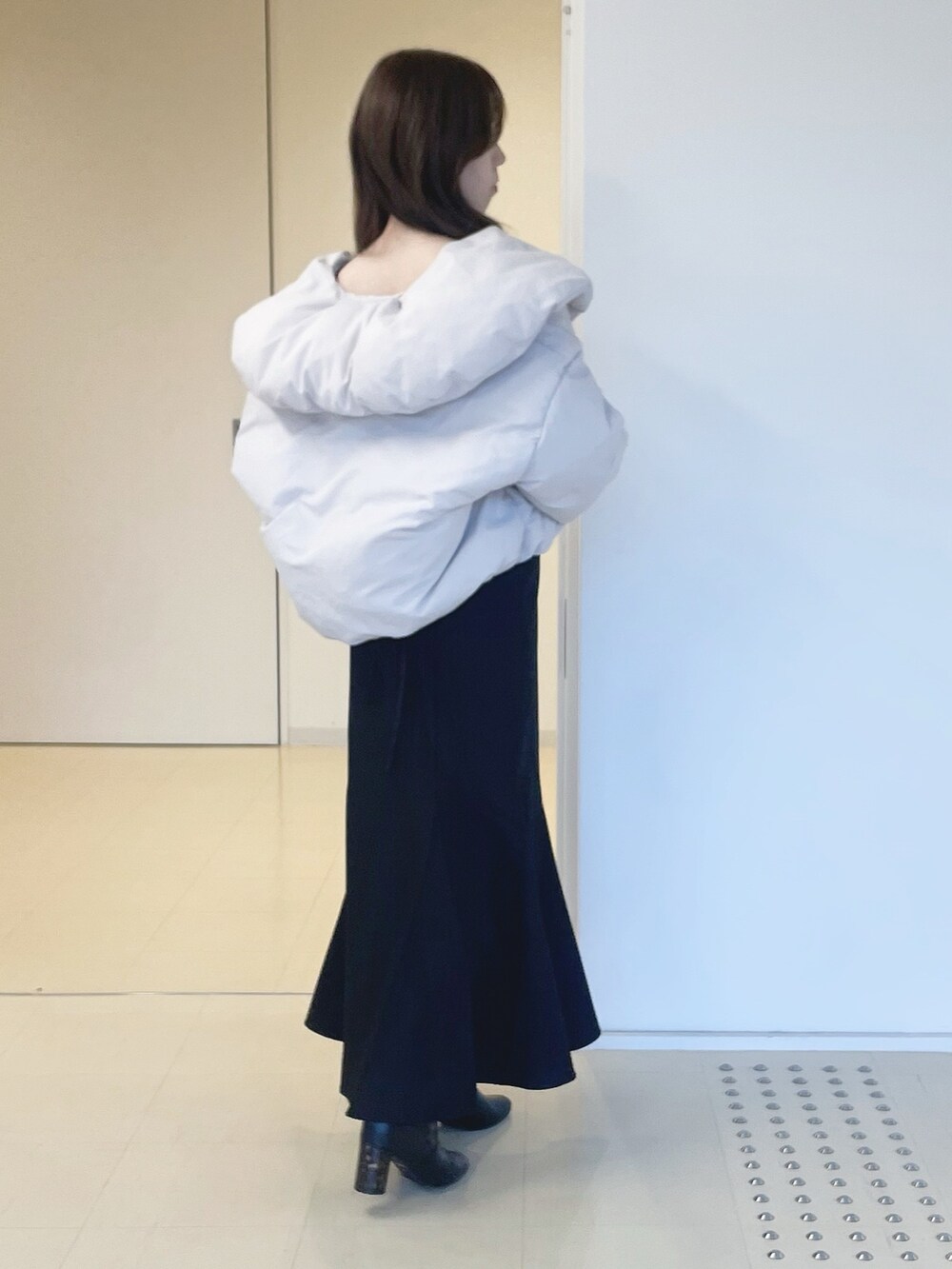 ブラック系のニット/セーター、ピンク系のダウンジャケット/コート、ブラック系のスカートを着用したレディースの冬コーディネートの4枚目の写真