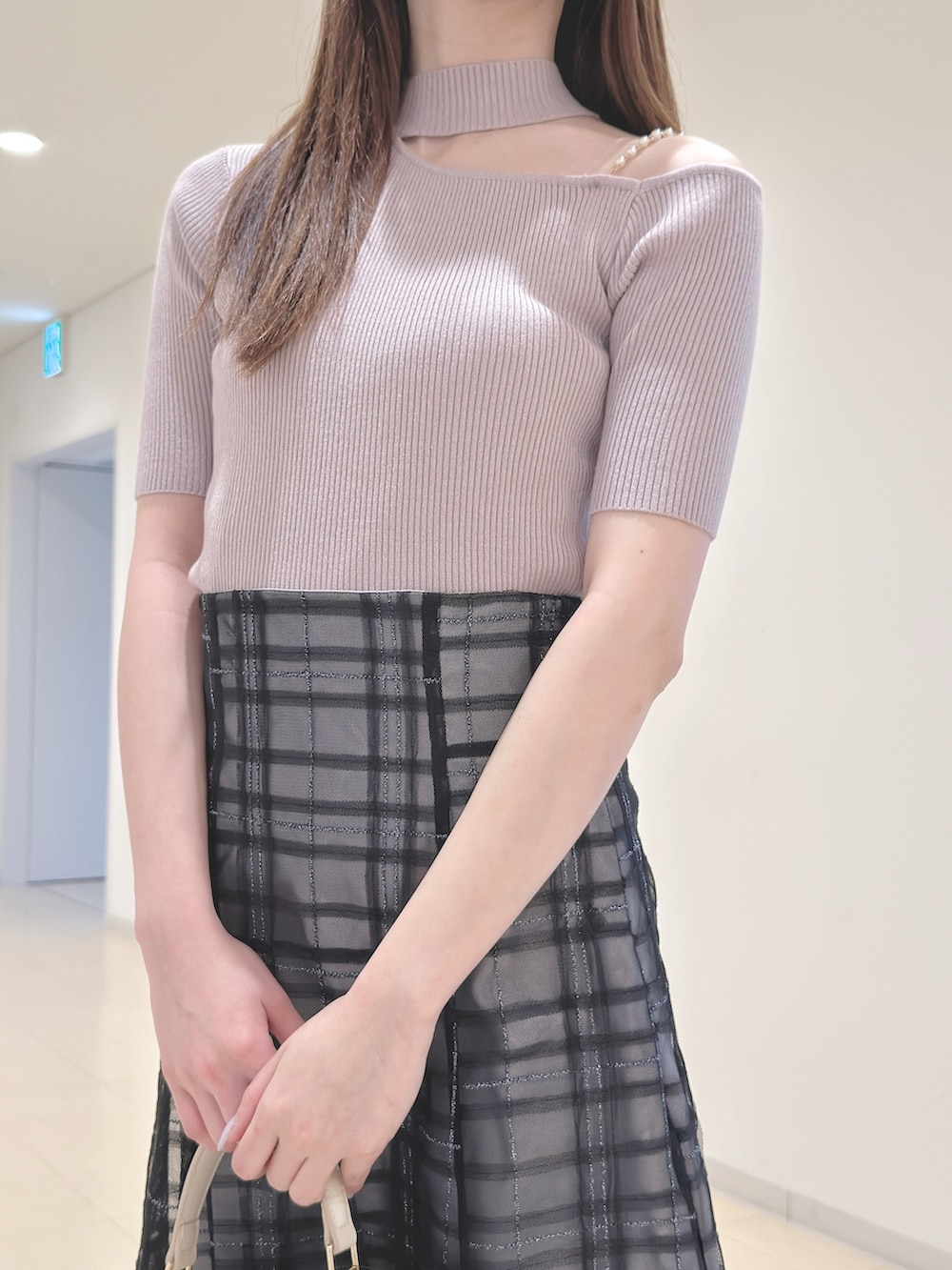 ベージュ系のニット/セーター、ブルー系のスカート、ホワイト系のハンドバッグを着用したレディースの春コーディネートの6枚目の写真