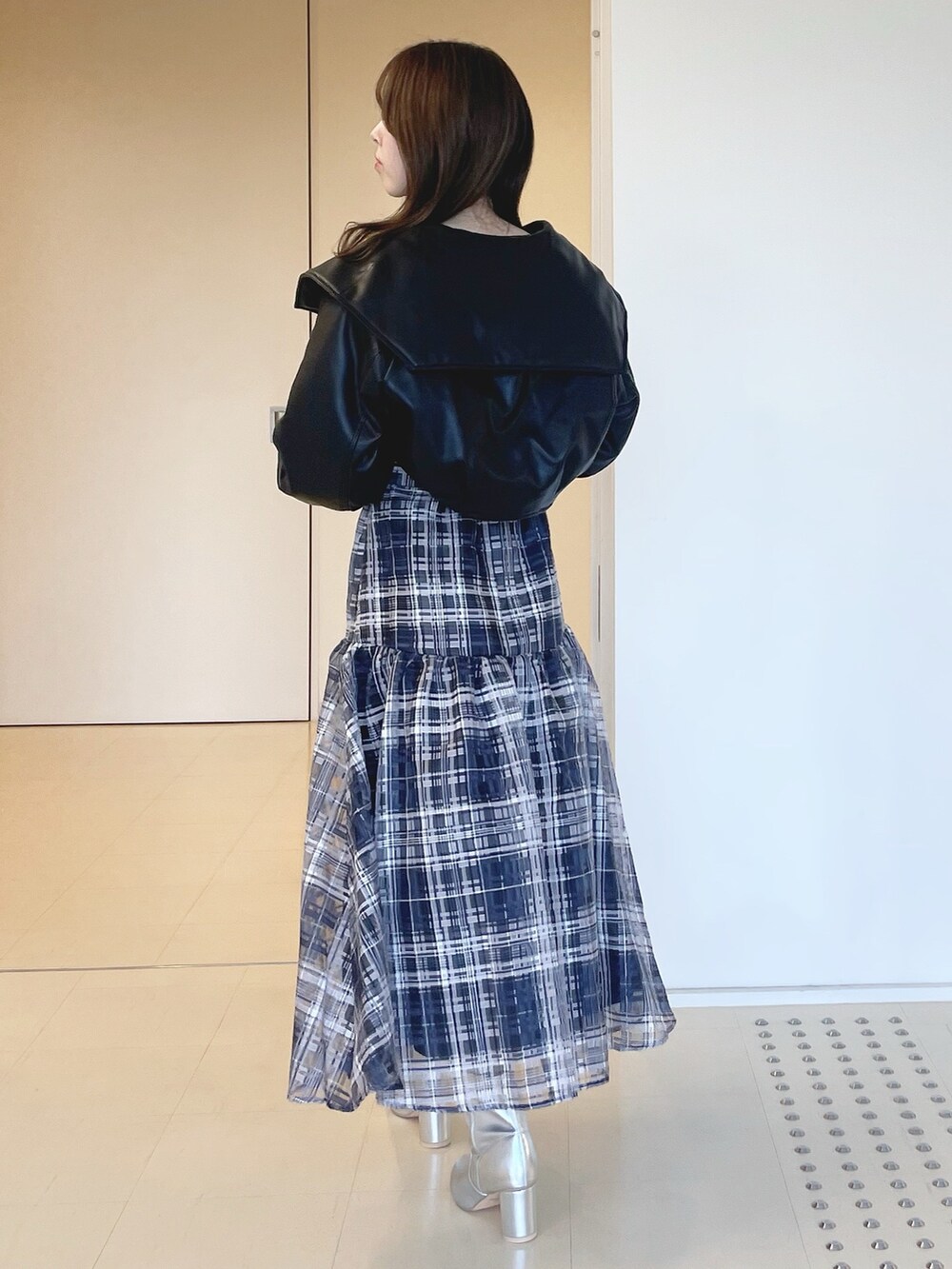 ブルー系のワンピース、シルバー系のブーツ、ブラック系のライダースジャケットを着用したレディースの冬コーディネートの4枚目の写真