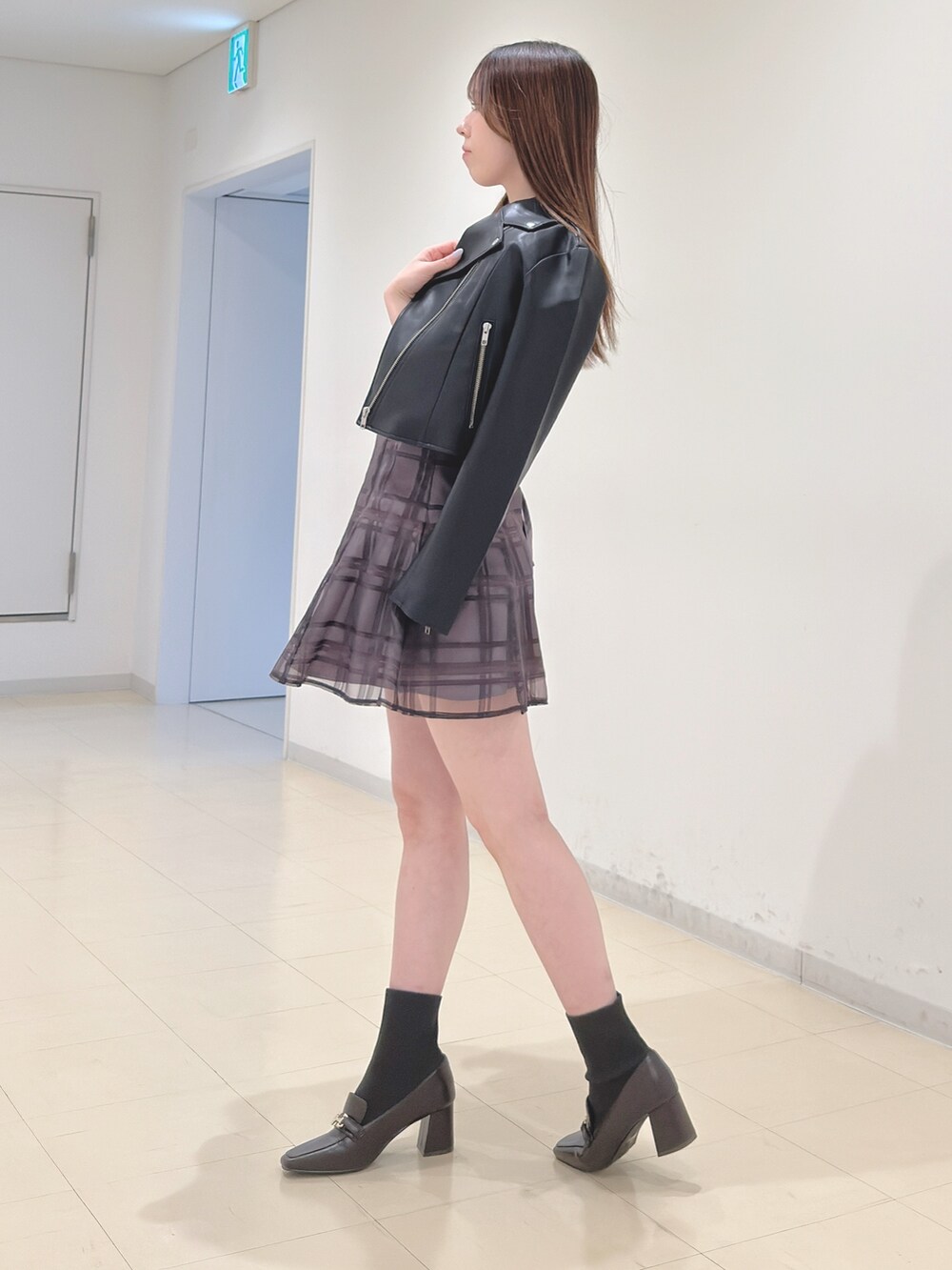 ブラック系のライダースジャケット、ベージュ系のニット/セーター、ブラウン系のその他パンツを着用したレディースの春コーディネートの4枚目の写真