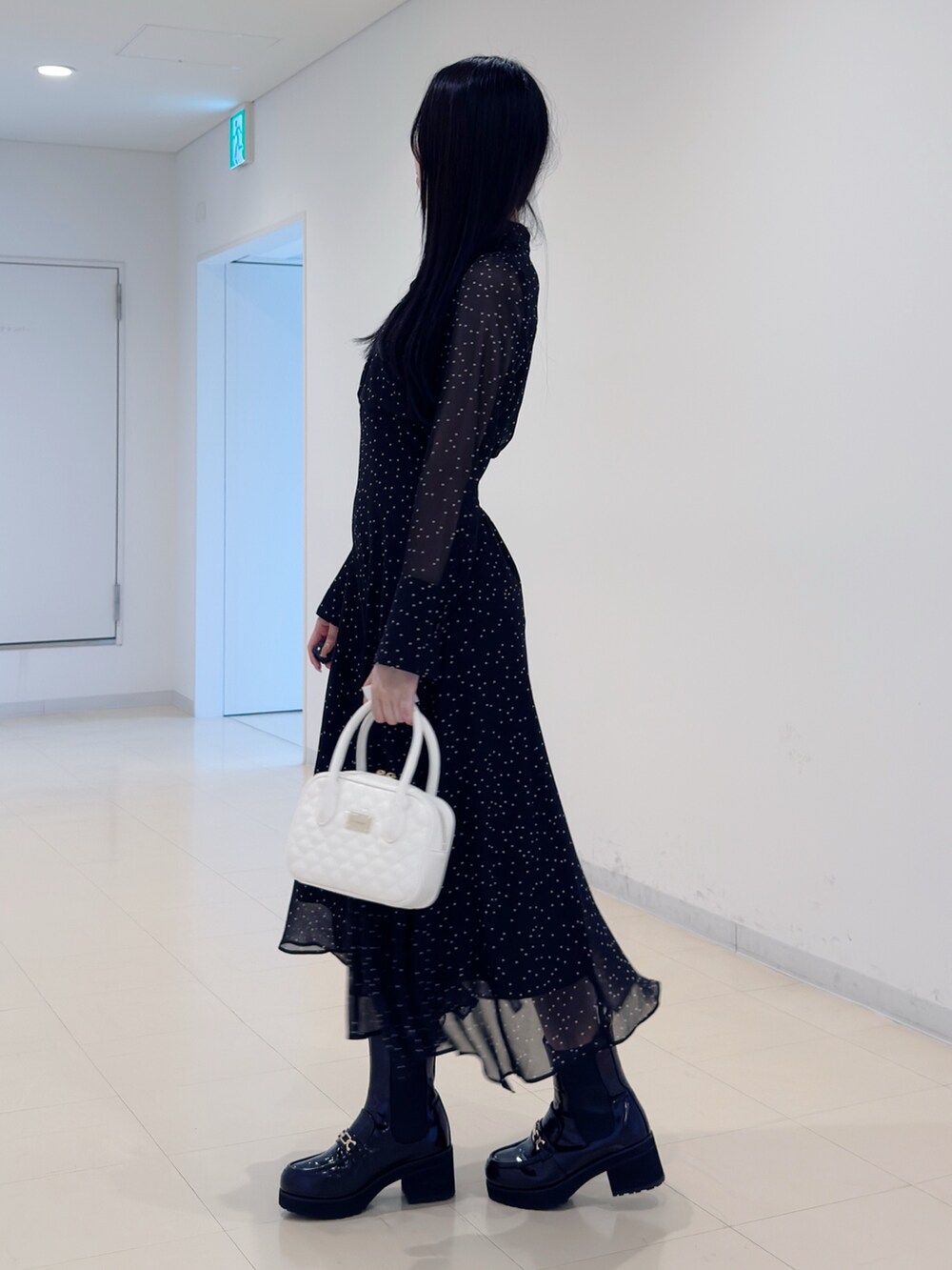 その他のワンピース、ホワイト系のハンドバッグ、ブラック系のブーツを着用したレディースの秋コーディネートの4枚目の写真