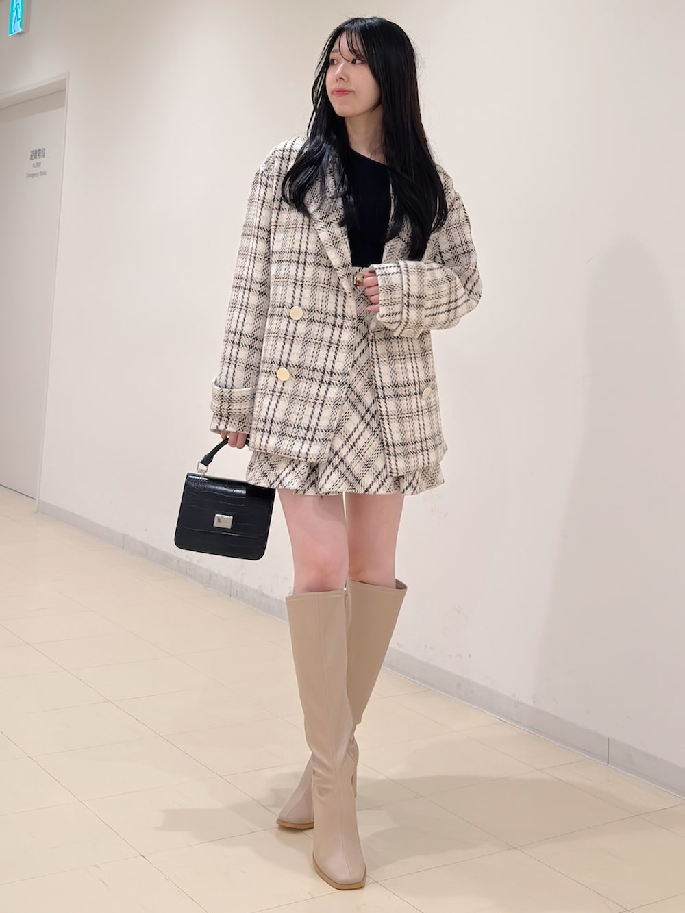 ブラック系のニット/セーター、ホワイト系のその他アウター、ホワイト系のその他パンツを着用したレディースの秋コーディネートの3枚目の写真