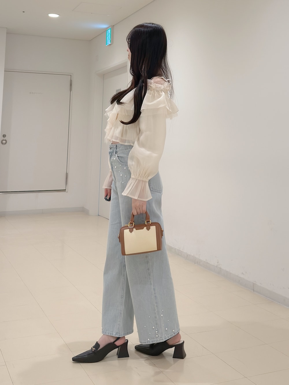 ホワイト系のシャツ/ブラウス、ブルー系のデニムパンツ、ブラウン系のハンドバッグを着用したレディースの春コーディネートの4枚目の写真