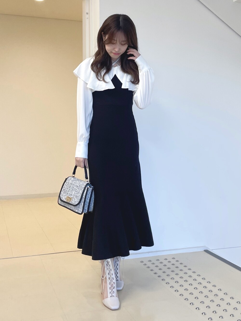 ホワイト系のブーツ、ブラック系のショルダーバッグ、ブラック系のワンピースを着用したレディースの秋コーディネートの3枚目の写真