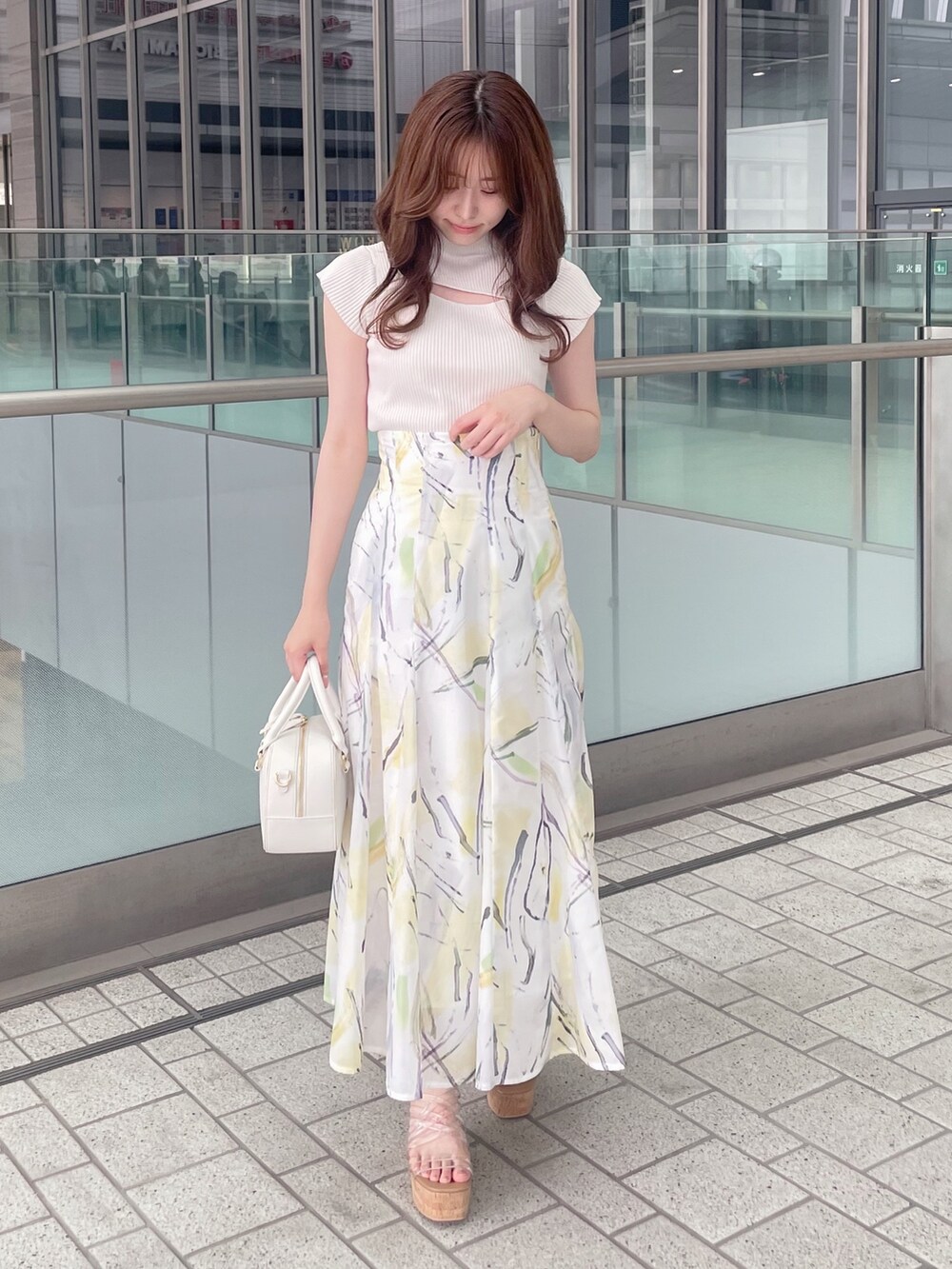ホワイト系のニット/セーター、イエロー系のスカート、ホワイト系のボストンバッグを着用したレディースの夏コーディネートの4枚目の写真
