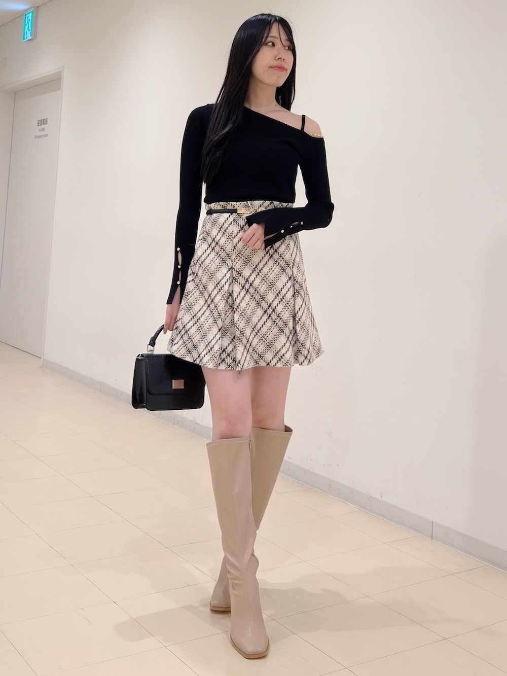 ブラック系のニット/セーター、ホワイト系のその他パンツ、ベージュ系のブーツを着用したレディースの秋コーディネートの3枚目の写真