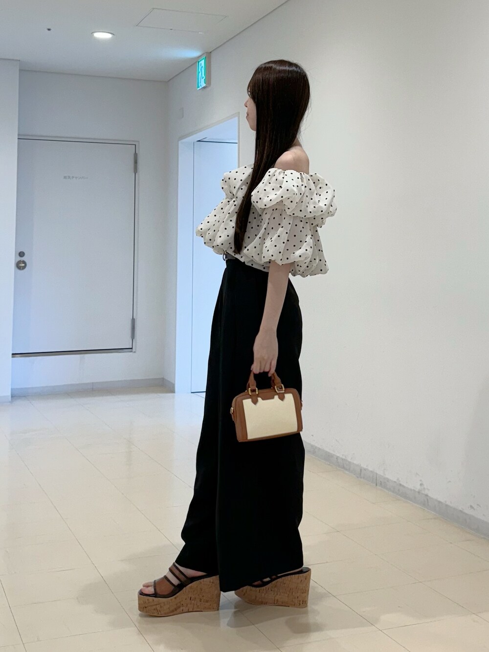 ホワイト系のシャツ/ブラウス、ブラック系のその他パンツ、ブラウン系のハンドバッグを着用したレディースの夏コーディネートの3枚目の写真