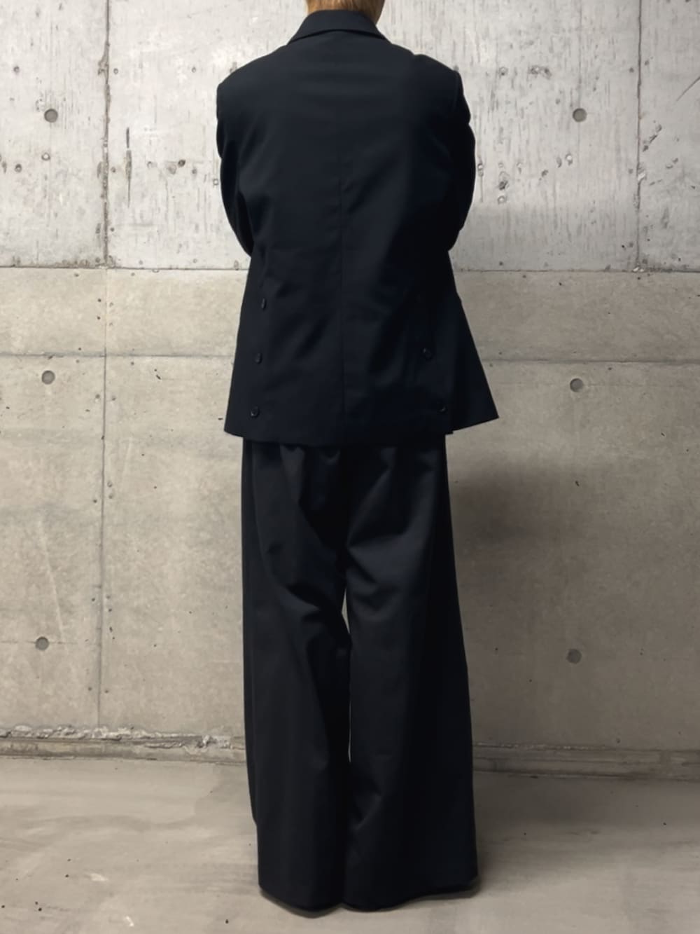 ブラック系のTシャツ/カットソー、ブラック系のテーラードジャケット、ブラック系のスラックスを着用したメンズの冬コーディネートの3枚目の写真