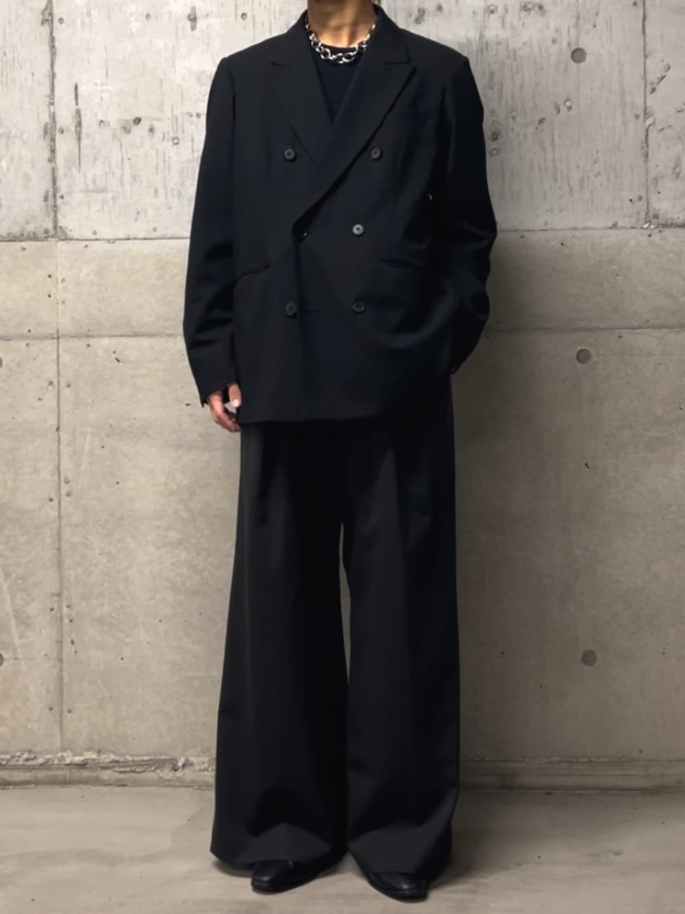 ブラック系のTシャツ/カットソー、ブラック系のテーラードジャケット、ブラック系のスラックスを着用したメンズの冬コーディネートの2枚目の写真