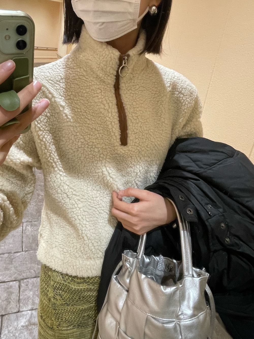 グリーン系のスカート、シルバー系のショルダーバッグ、ホワイト系のトップスを着用したレディースの冬コーディネートの3枚目の写真