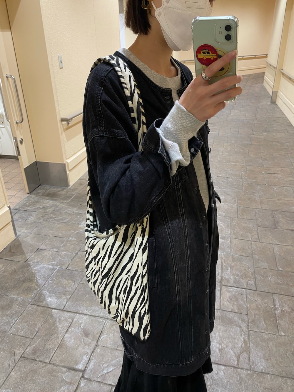 ブラック系のデニムジャケット、グレー系のスウェット、その他のトートバッグを着用したレディースの春コーディネートの2枚目の写真