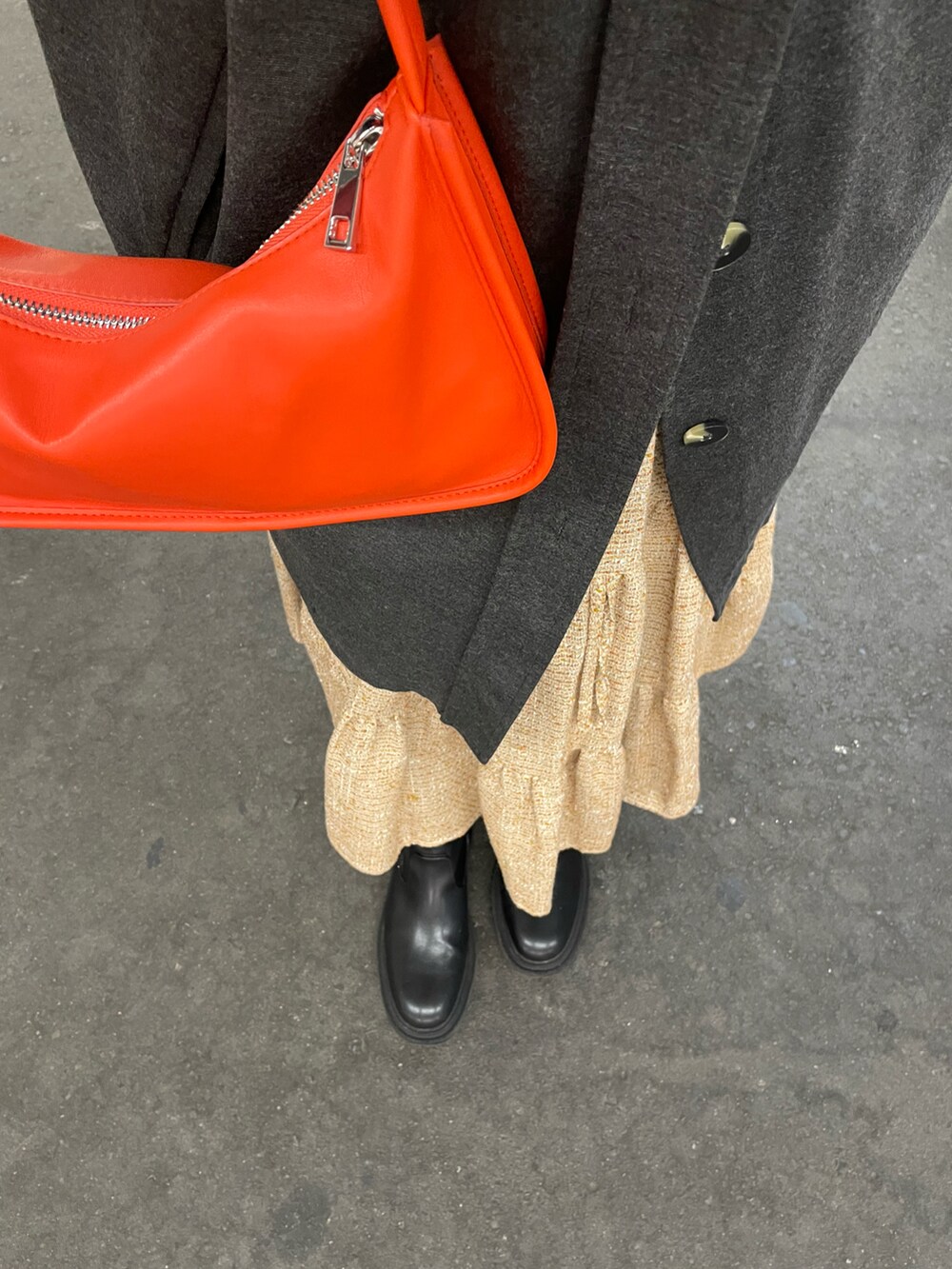 オレンジ系のショルダーバッグ、グレー系のジャケット/アウター、オレンジ系のスカートを着用したレディースの冬コーディネートの3枚目の写真