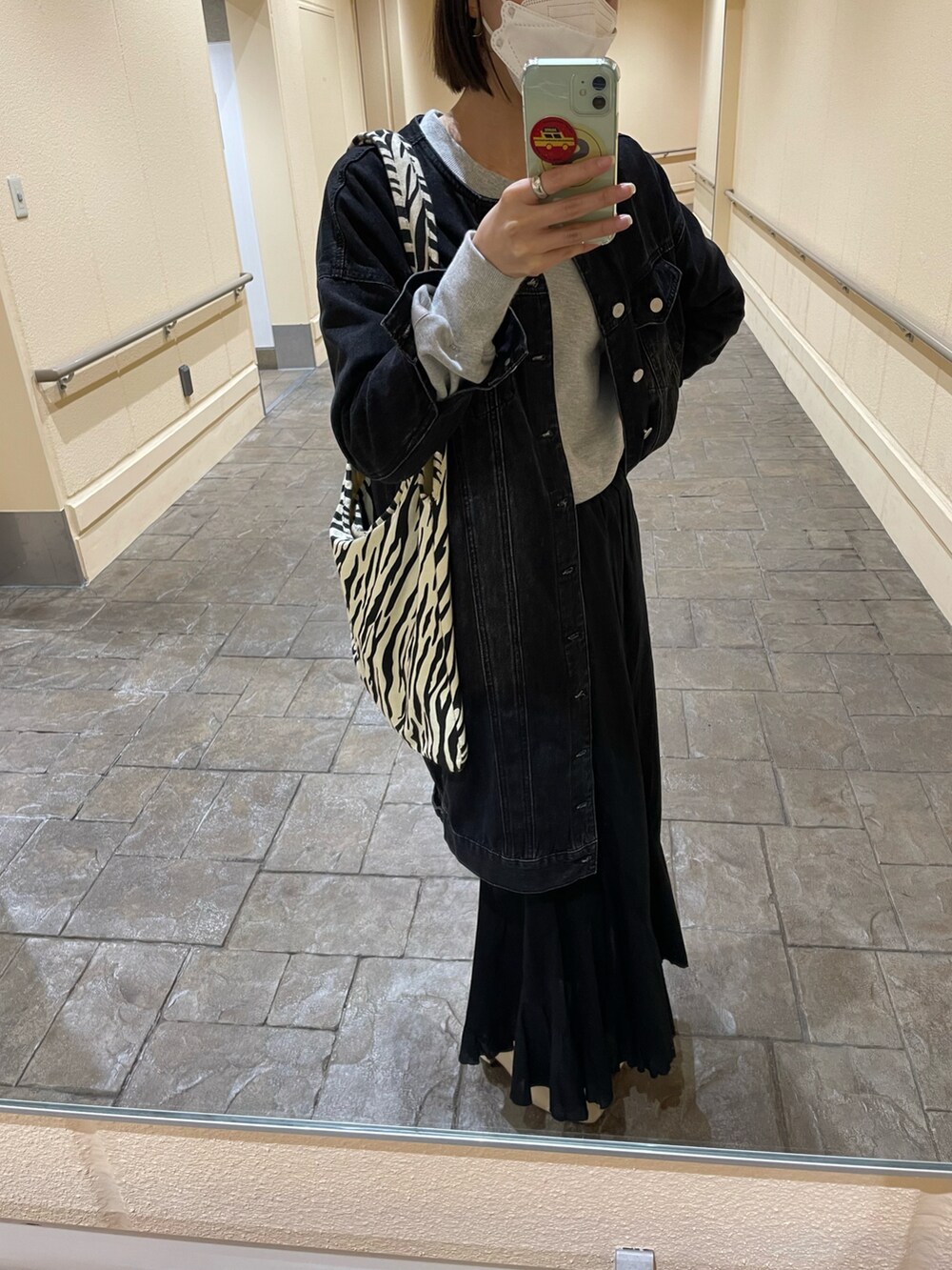 ブラック系のデニムジャケット、グレー系のスウェット、その他のトートバッグを着用したレディースの春コーディネートの3枚目の写真