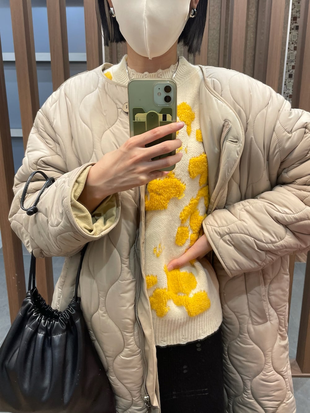 イエロー系のニット/セーター、ホワイト系のその他アウター、ブラック系のブーツを着用したレディースの秋コーディネートの2枚目の写真