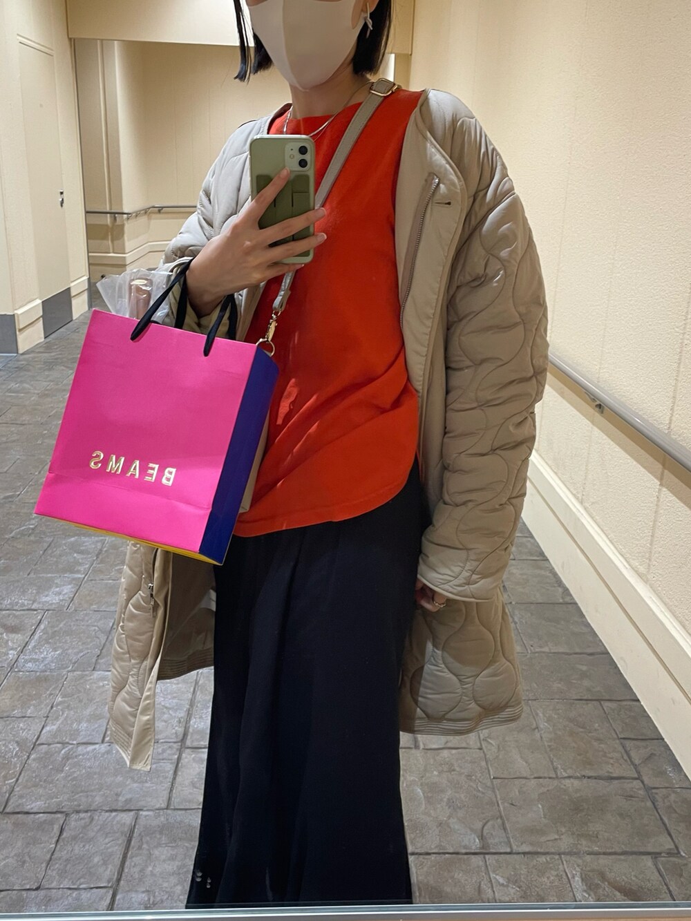 ブラック系のスカート、ホワイト系のその他アウター、ベージュ系のブーツを着用したレディースの冬コーディネートの3枚目の写真