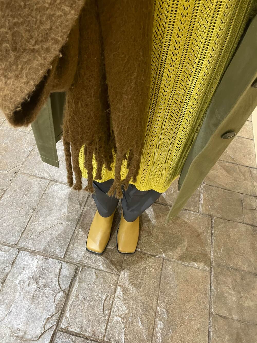 イエロー系のカーディガン/ボレロ、グレー系のスラックス、ベージュ系のブーツを着用したレディースの冬コーディネートの3枚目の写真