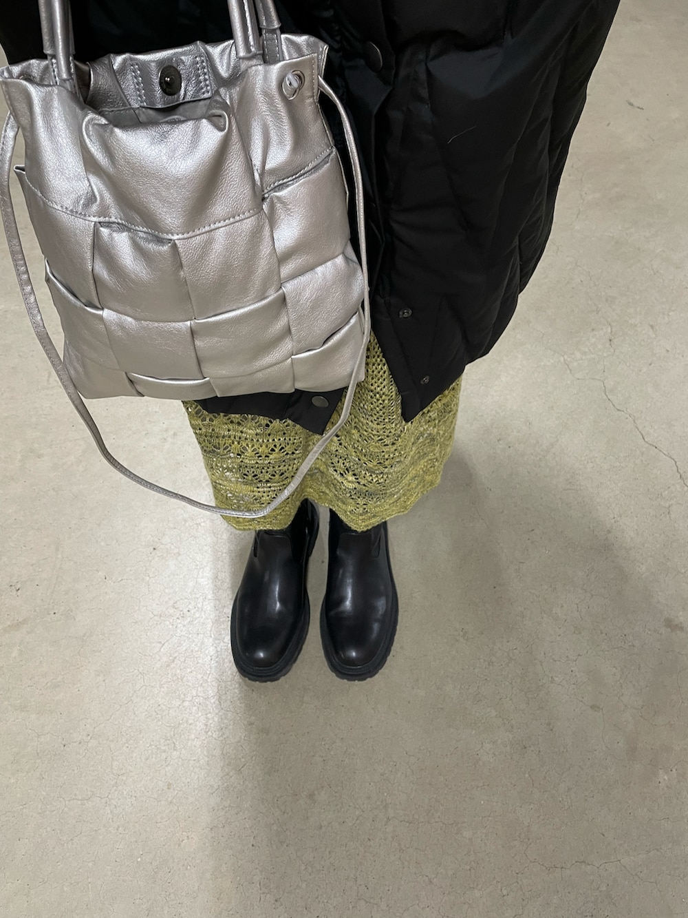 グリーン系のスカート、シルバー系のショルダーバッグ、ホワイト系のトップスを着用したレディースの冬コーディネートの4枚目の写真