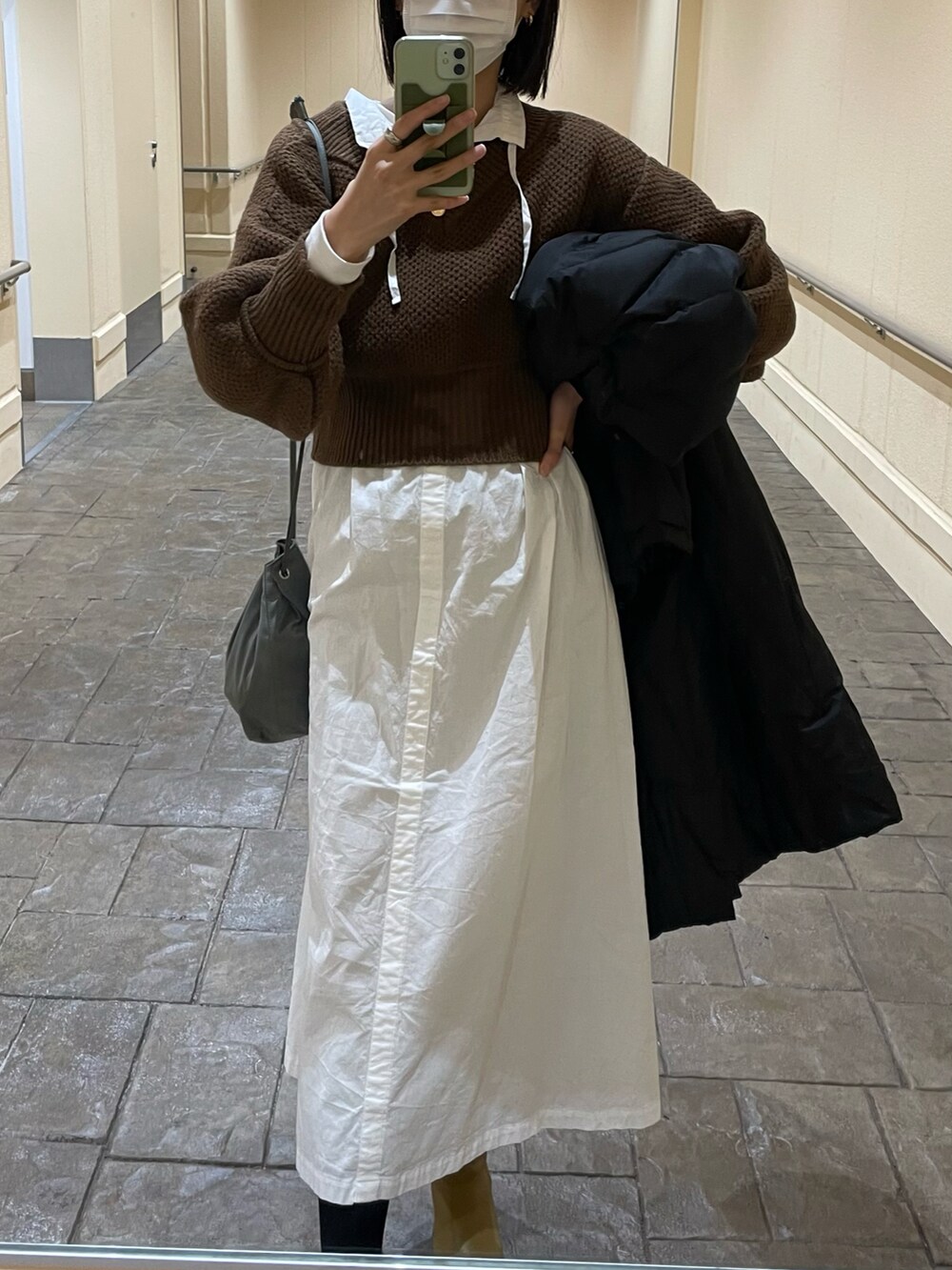 ホワイト系のワンピース/ドレス、ベージュ系のブーツ、ブラウン系のニット/セーターを着用したレディースの冬コーディネートの2枚目の写真