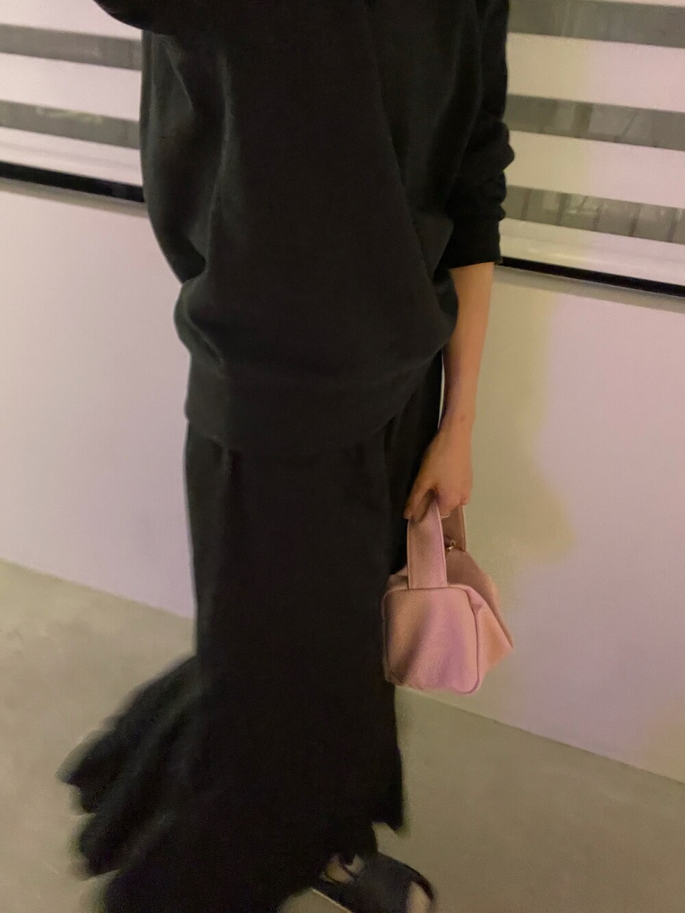 ブラック系のスカート、ピンク系のハンドバッグ、ブラック系のスウェットを着用したレディースの冬コーディネートの4枚目の写真