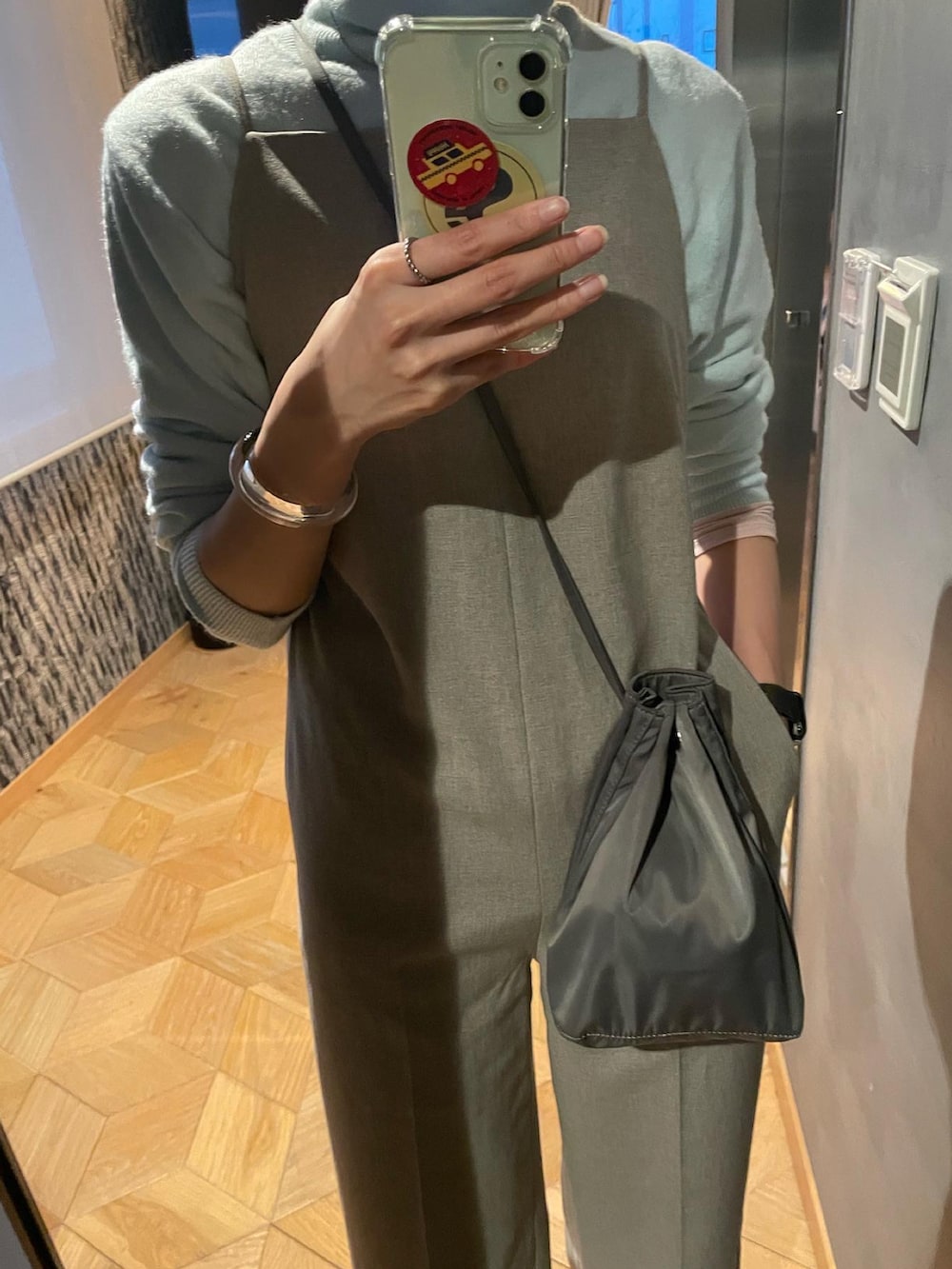 ベージュ系のつなぎ/オールインワン、グリーン系のショルダーバッグ、ベージュ系のブーツを着用したレディースの冬コーディネートの2枚目の写真