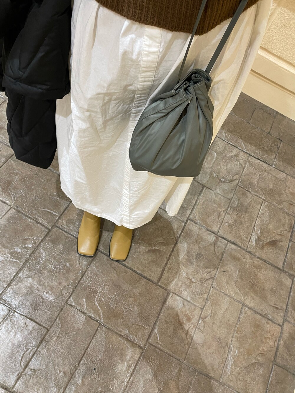 ホワイト系のワンピース/ドレス、ベージュ系のブーツ、ブラウン系のニット/セーターを着用したレディースの冬コーディネートの4枚目の写真