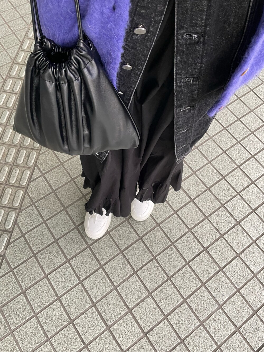 パープル系のカーディガン/ボレロ、ブラック系のスカート、ホワイト系のスニーカーを着用したレディースの冬コーディネートの4枚目の写真
