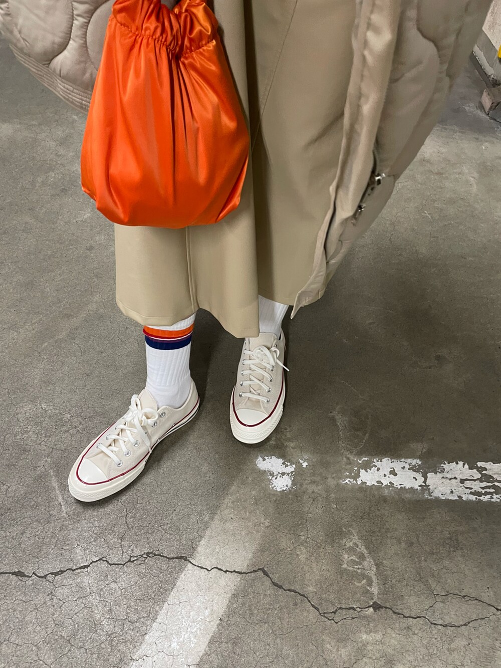 オレンジ系のバッグ、グレー系のスウェット、ホワイト系のスニーカーを着用したレディースの冬コーディネートの4枚目の写真