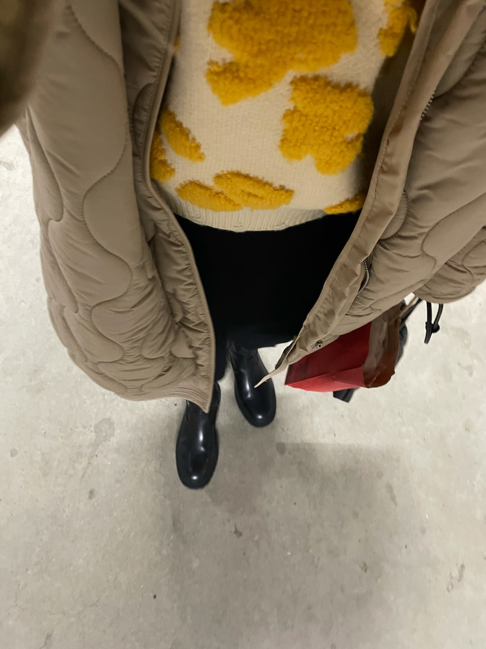 イエロー系のニット/セーター、ホワイト系のその他アウター、ブラック系のブーツを着用したレディースの秋コーディネートの3枚目の写真