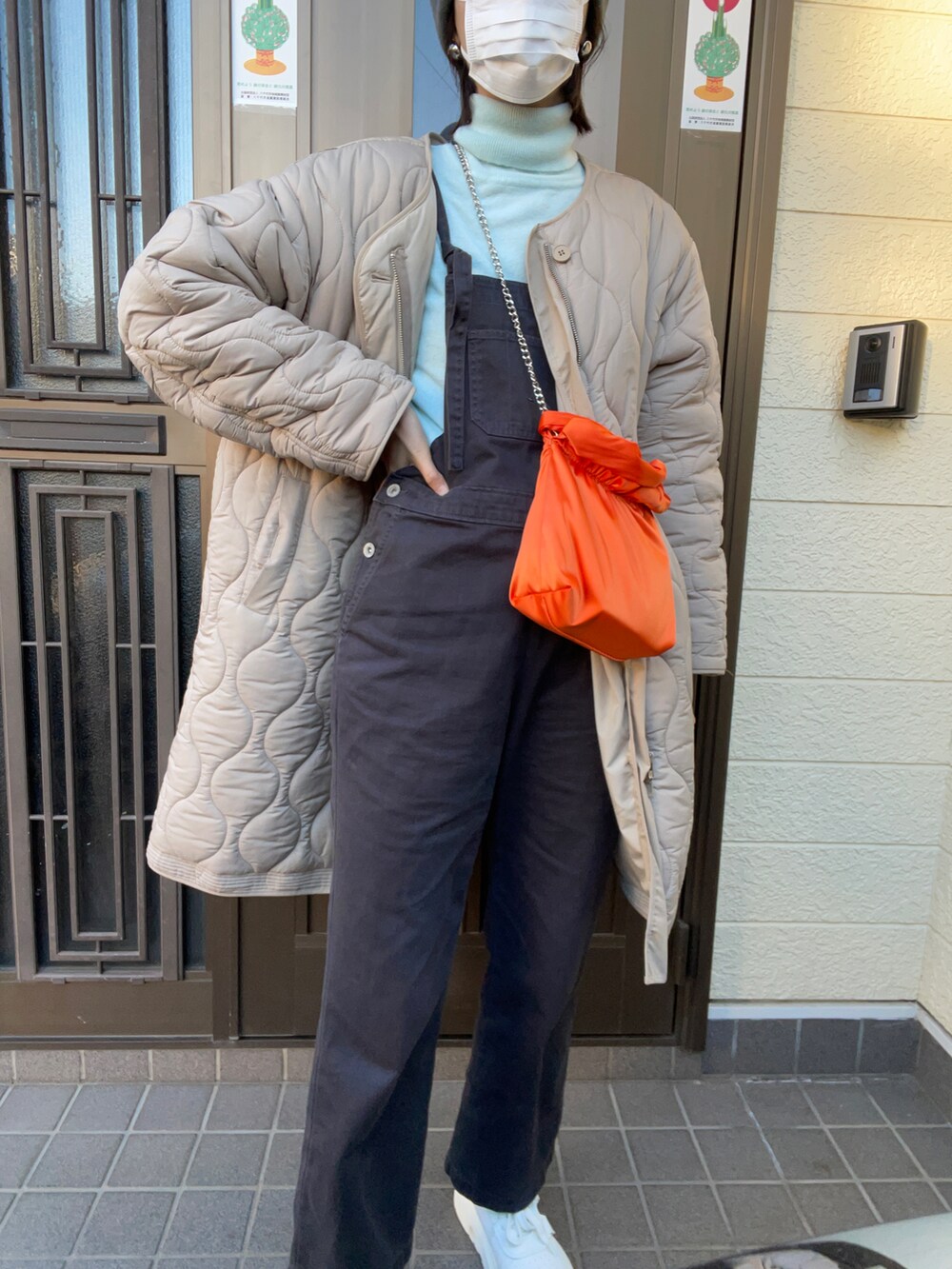 ホワイト系のスニーカー、ブラック系のサロペット/オーバーオール、オレンジ系のバッグを着用したレディースの冬コーディネートの2枚目の写真
