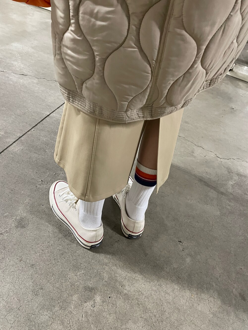 オレンジ系のバッグ、グレー系のスウェット、ホワイト系のスニーカーを着用したレディースの冬コーディネートの5枚目の写真