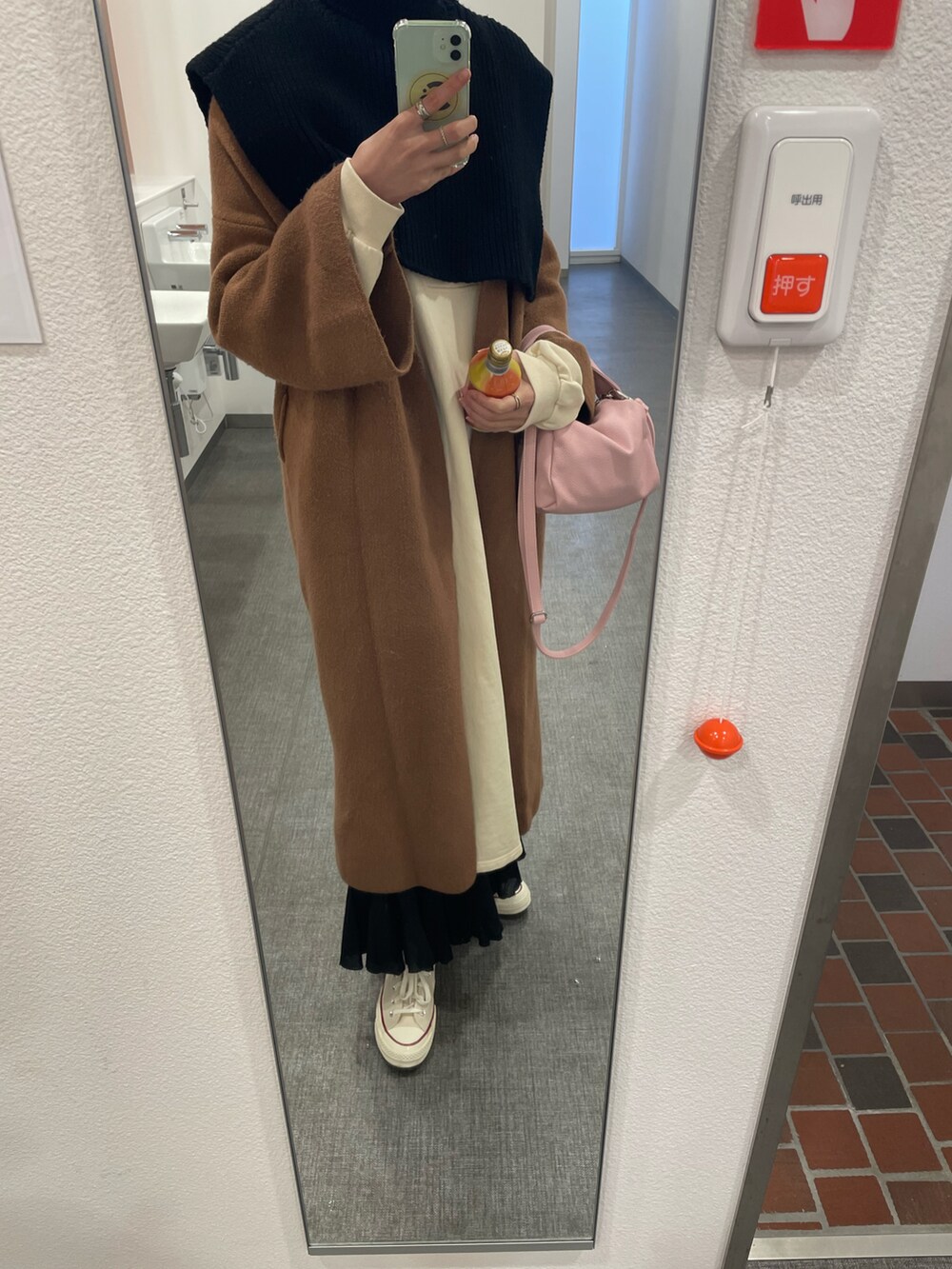 ブラック系のニット/セーター、ブラウン系のその他アウター、ピンク系のハンドバッグを着用したレディースの冬コーディネートの2枚目の写真