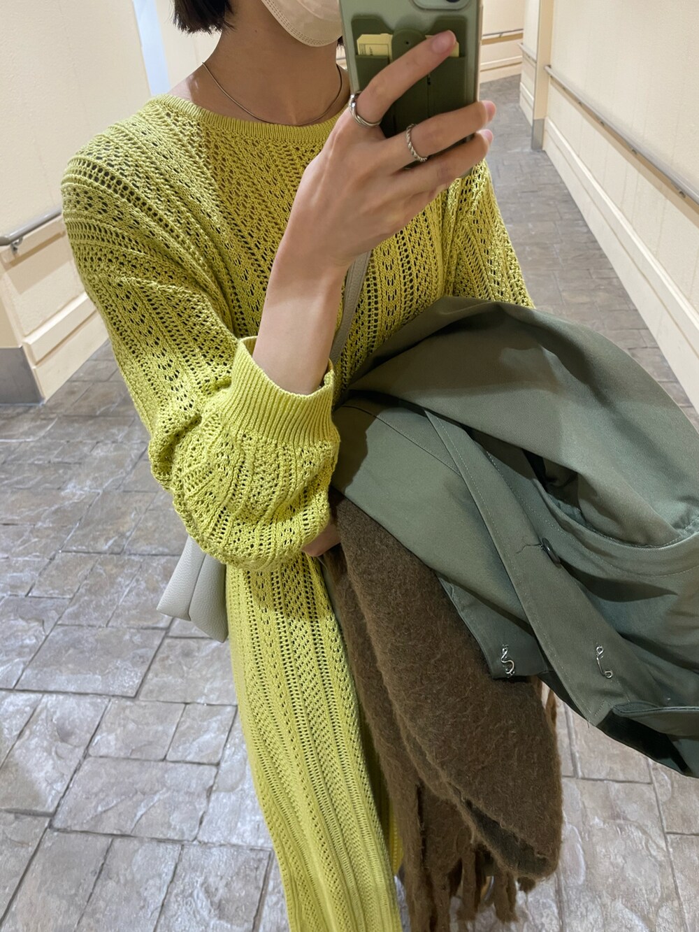 イエロー系のカーディガン/ボレロ、グレー系のスラックス、ベージュ系のブーツを着用したレディースの冬コーディネートの2枚目の写真