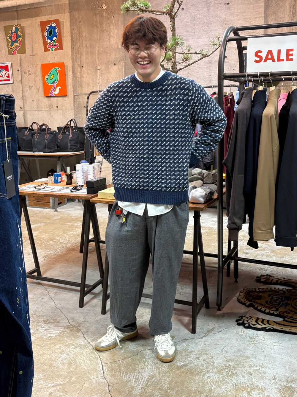 ブルー系のデニムジャケット、ブルー系のニット/セーター、グレー系のスラックスを着用したメンズの冬コーディネートの4枚目の写真