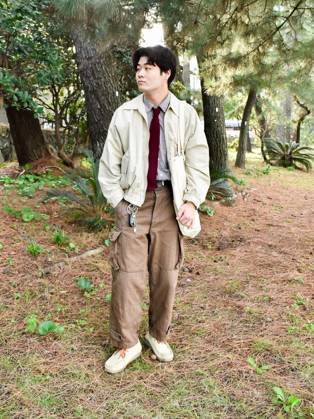 ベージュ系のブルゾン、ブラウン系のカーゴパンツ、ベージュ系のモカシン/デッキシューズを着用したメンズの秋コーディネートの2枚目の写真