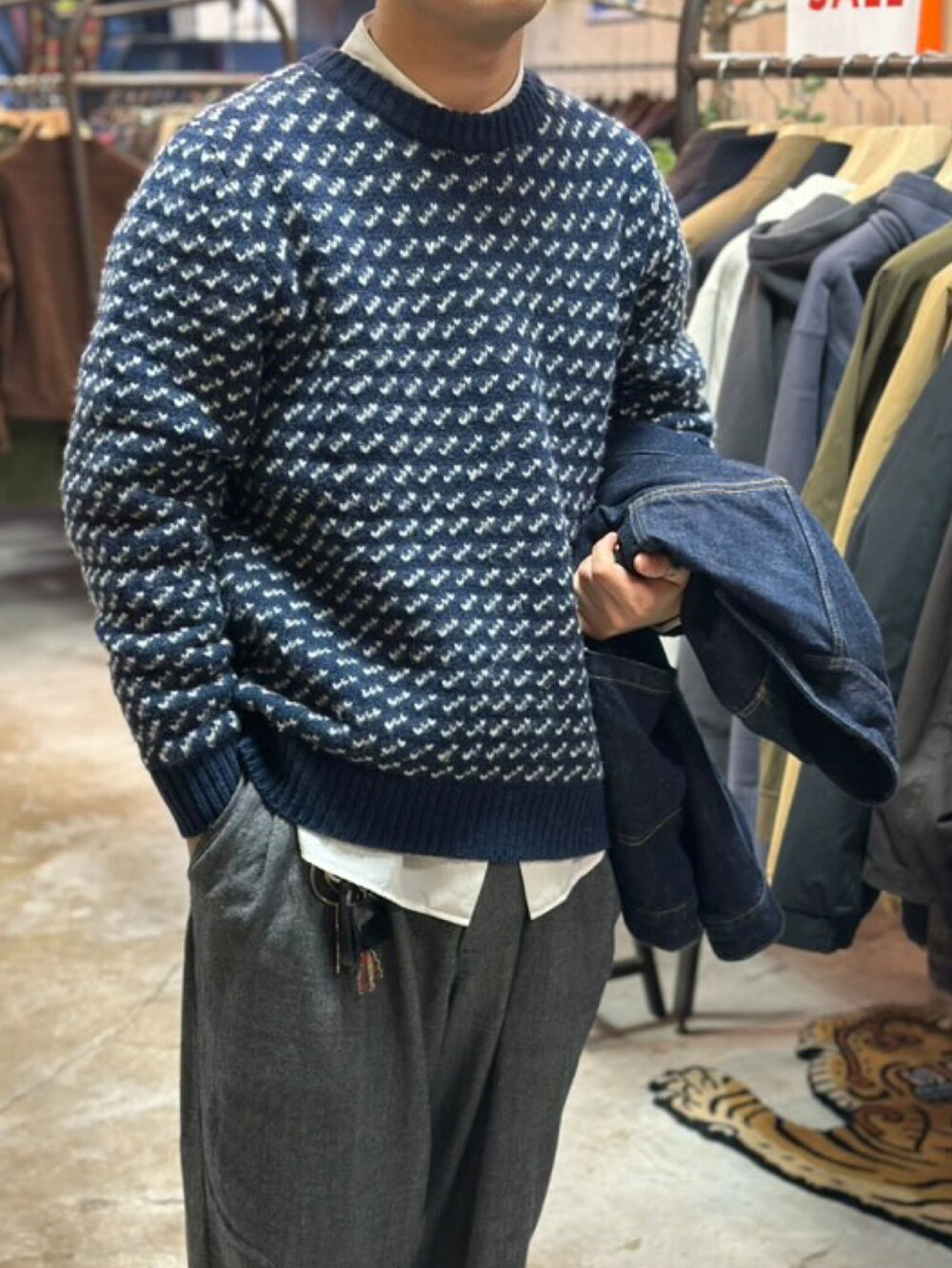 ブルー系のデニムジャケット、ブルー系のニット/セーター、グレー系のスラックスを着用したメンズの冬コーディネートの2枚目の写真