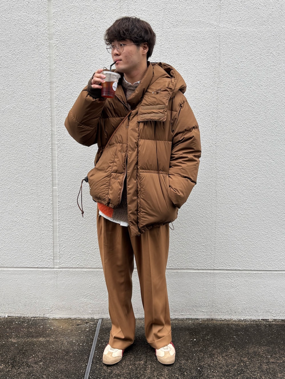 ベージュ系のスニーカー、ベージュ系のスラックス、ブラウン系のダウンジャケット/コートを着用したメンズの冬コーディネートの3枚目の写真