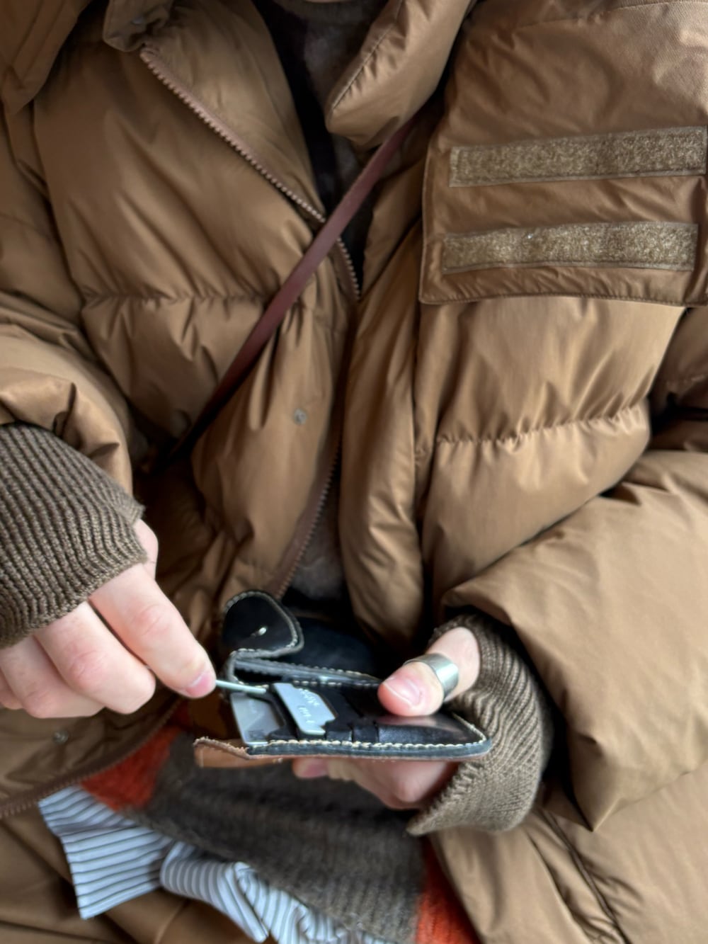 ベージュ系のスニーカー、ベージュ系のスラックス、ブラウン系のダウンジャケット/コートを着用したメンズの冬コーディネートの4枚目の写真