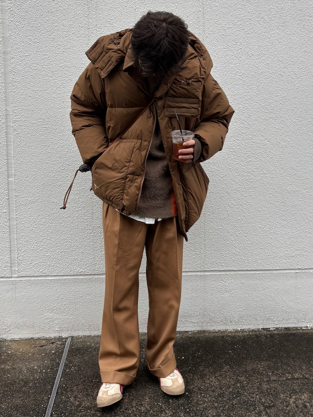 ベージュ系のスニーカー、ベージュ系のスラックス、ブラウン系のダウンジャケット/コートを着用したメンズの冬コーディネートの2枚目の写真