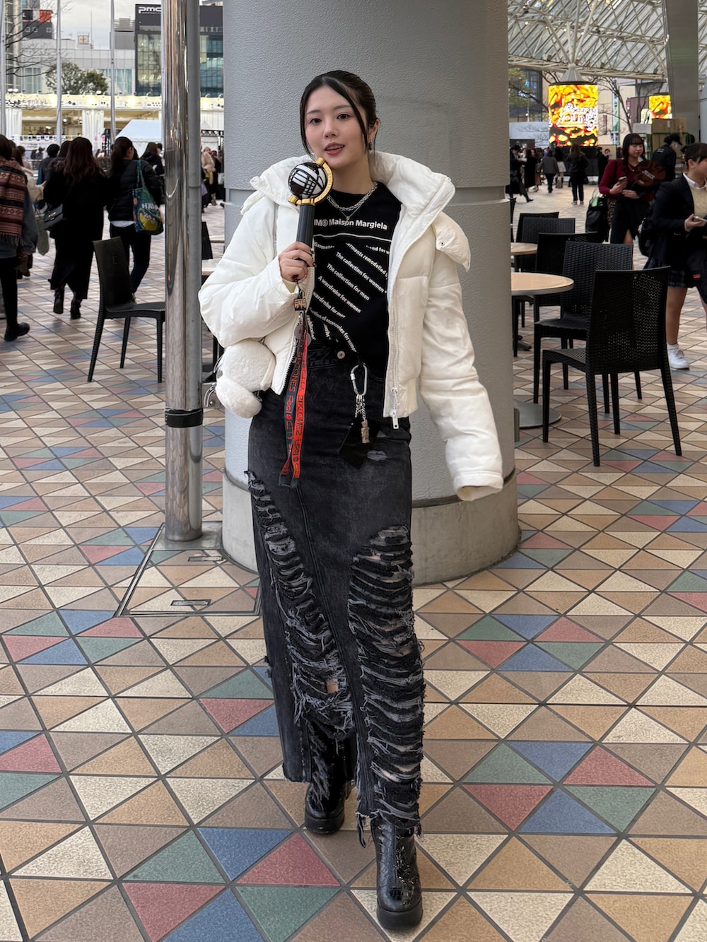 ブラック系のスウェット、ブラック系のデニムスカート、ブラック系のブーツを着用したレディースの冬コーディネートの2枚目の写真