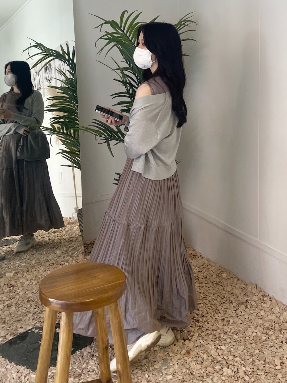 グレー系のショルダーバッグ、ブラウン系のニット/セーター、ベージュ系のスカートを着用したレディースの秋コーディネートの2枚目の写真