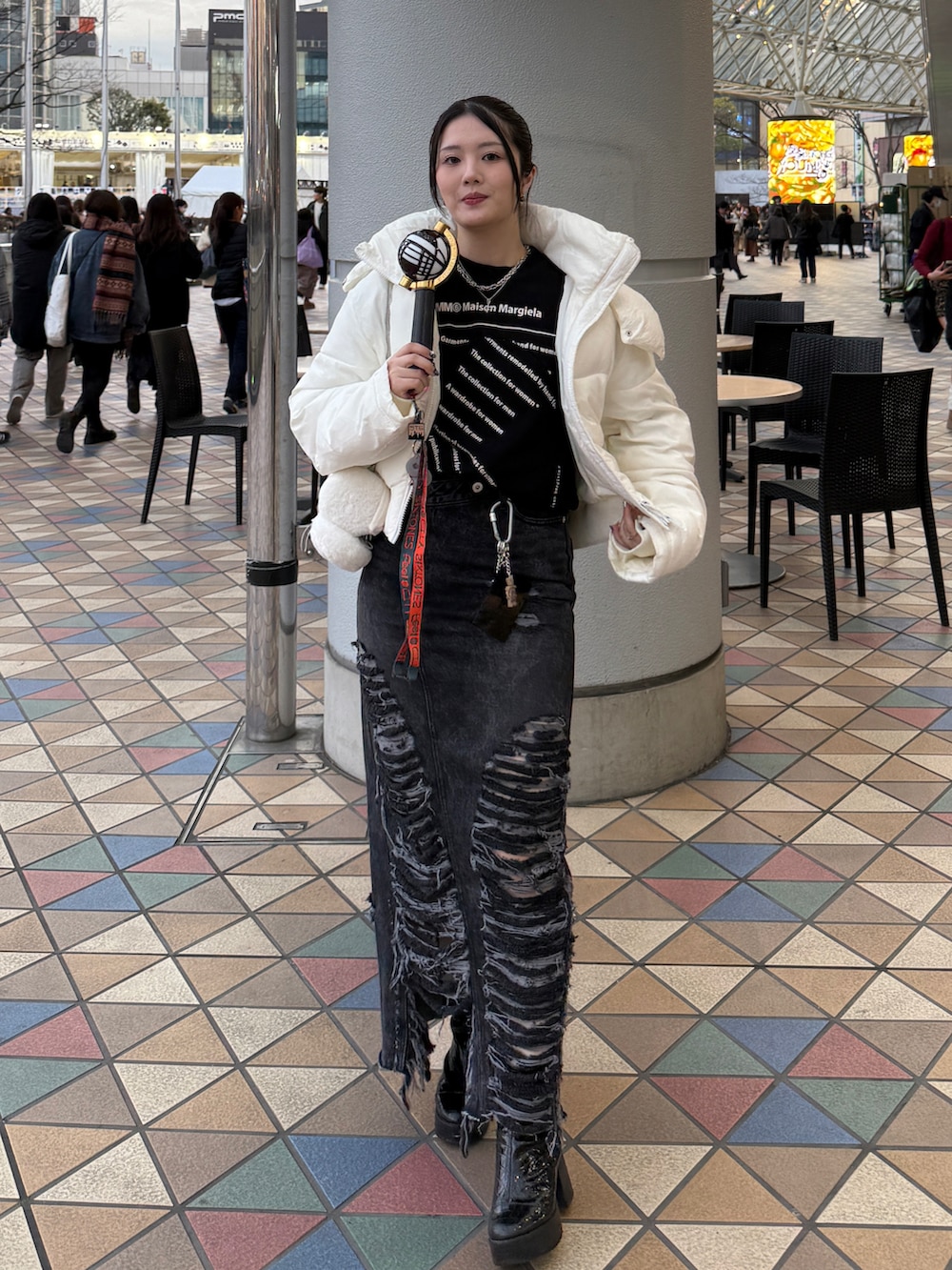 ブラック系のスウェット、ブラック系のデニムスカート、ブラック系のブーツを着用したレディースの冬コーディネートの3枚目の写真