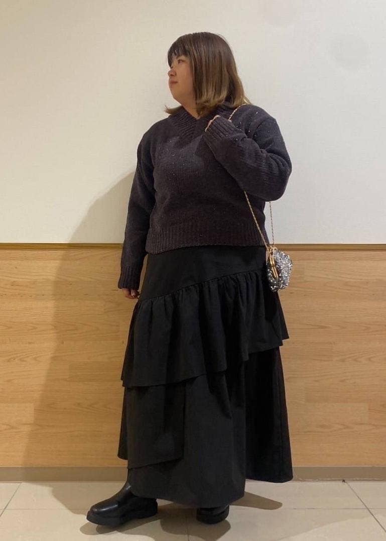 ブラック系のスカート、ブラック系のブーツ、グレー系のショルダーバッグを着用したレディースの冬コーディネートの10枚目の写真