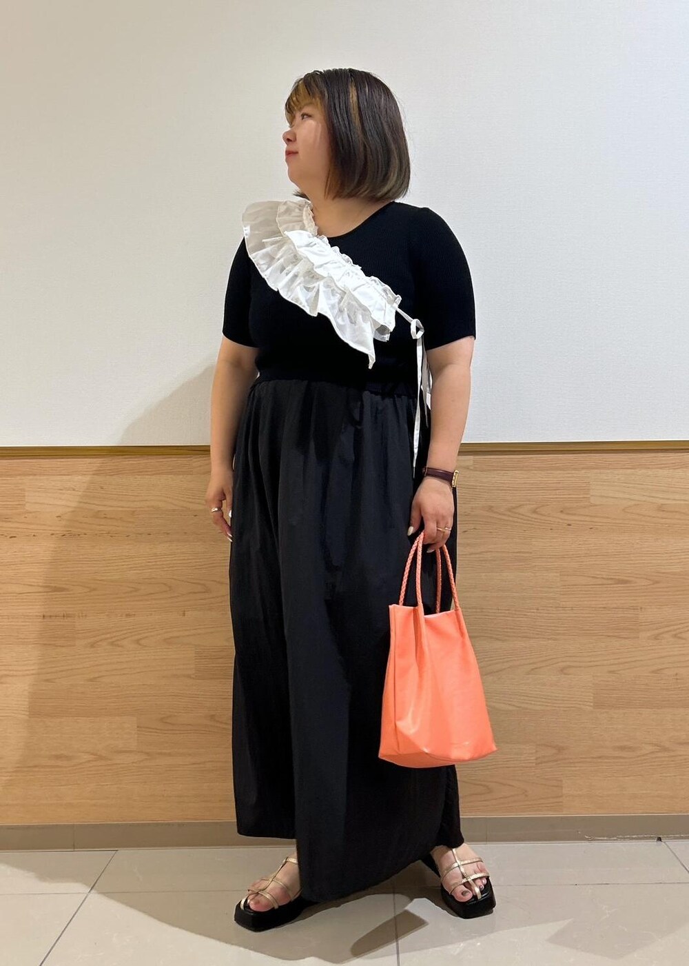 ゴールド系のサンダル、ピンク系のトートバッグ、ブラック系のワンピースを着用したレディースの夏コーディネートの9枚目の写真
