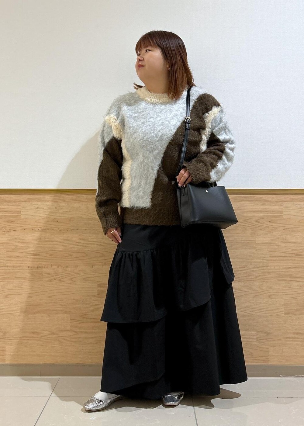 シルバー系のバレエシューズ、ブラック系のスカート、ブラウン系のニット/セーターを着用したレディースの秋コーディネートの10枚目の写真