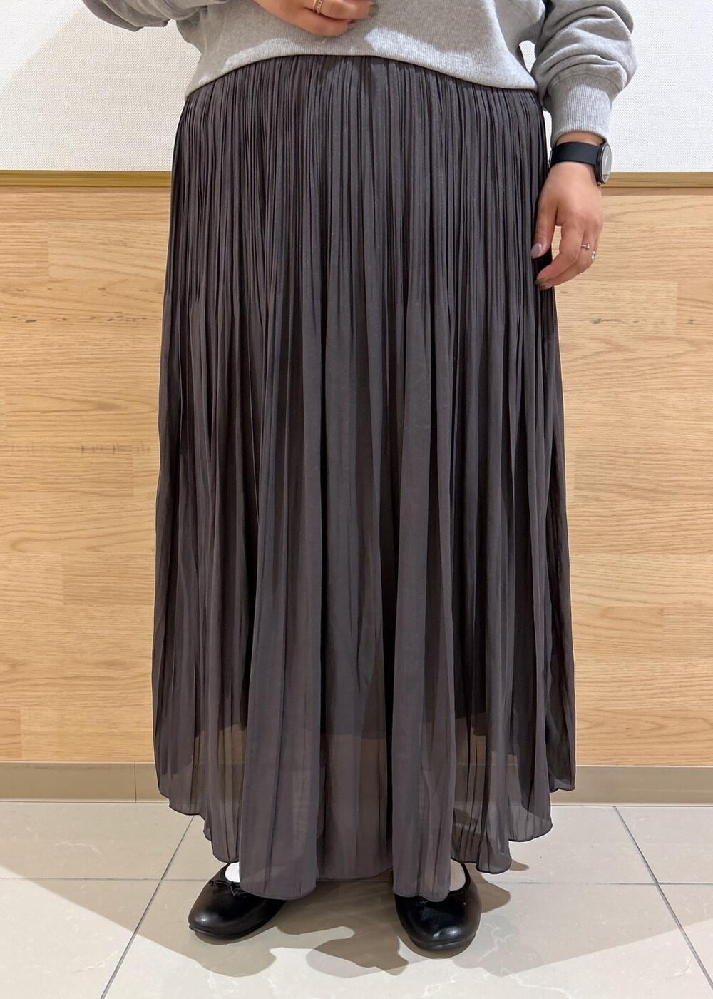 ブルー系のショルダーバッグ、ブラウン系のスカート、グレー系のパーカーを着用したレディースの秋コーディネートの6枚目の写真