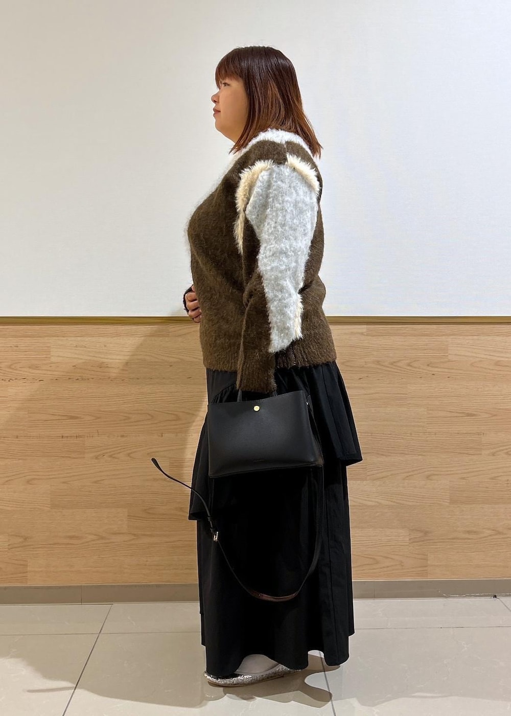 シルバー系のバレエシューズ、ブラック系のスカート、ブラウン系のニット/セーターを着用したレディースの秋コーディネートの2枚目の写真