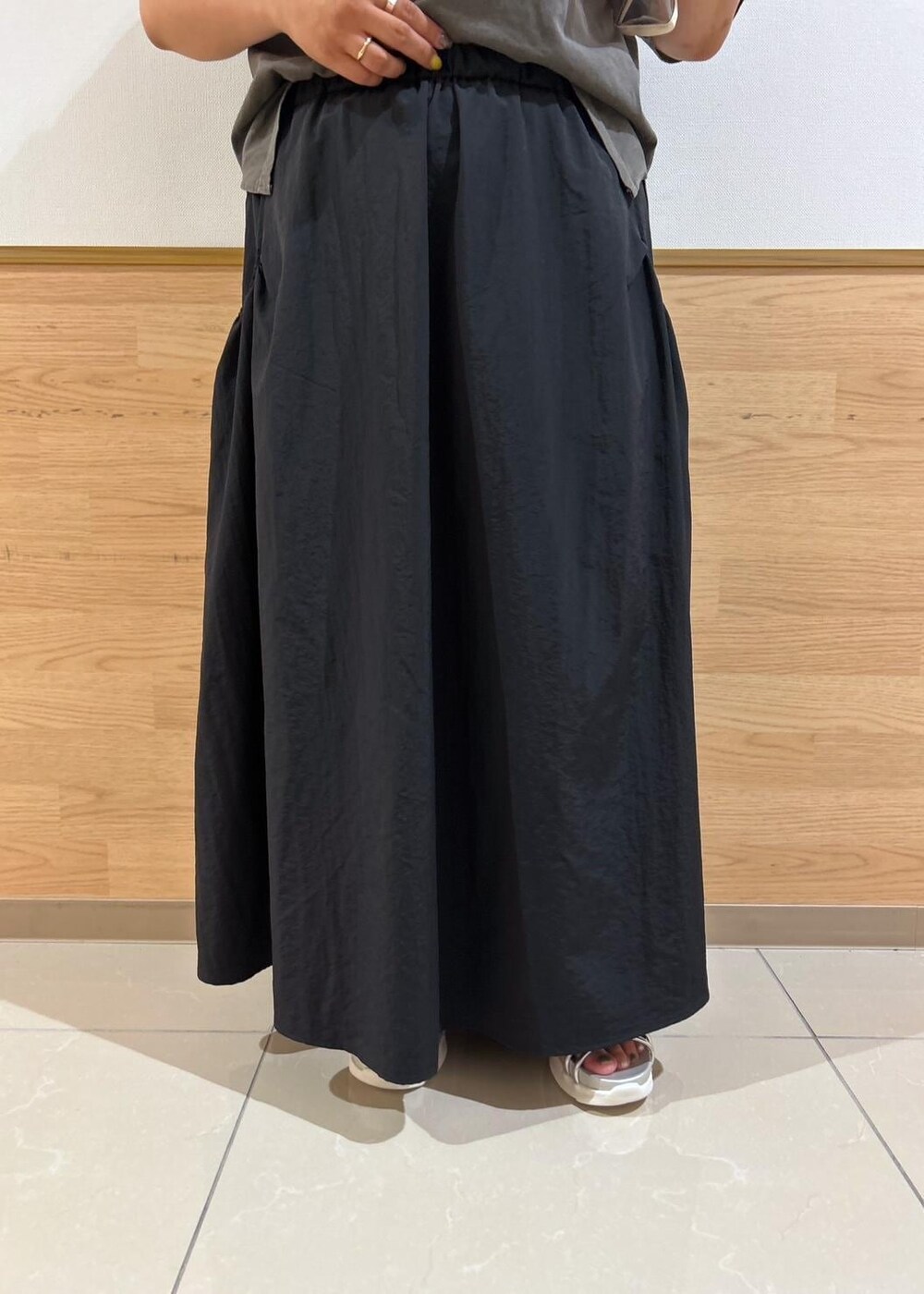 ブラック系のスカート、シルバー系のサンダル、グレー系のショルダーバッグを着用したレディースの夏コーディネートの5枚目の写真