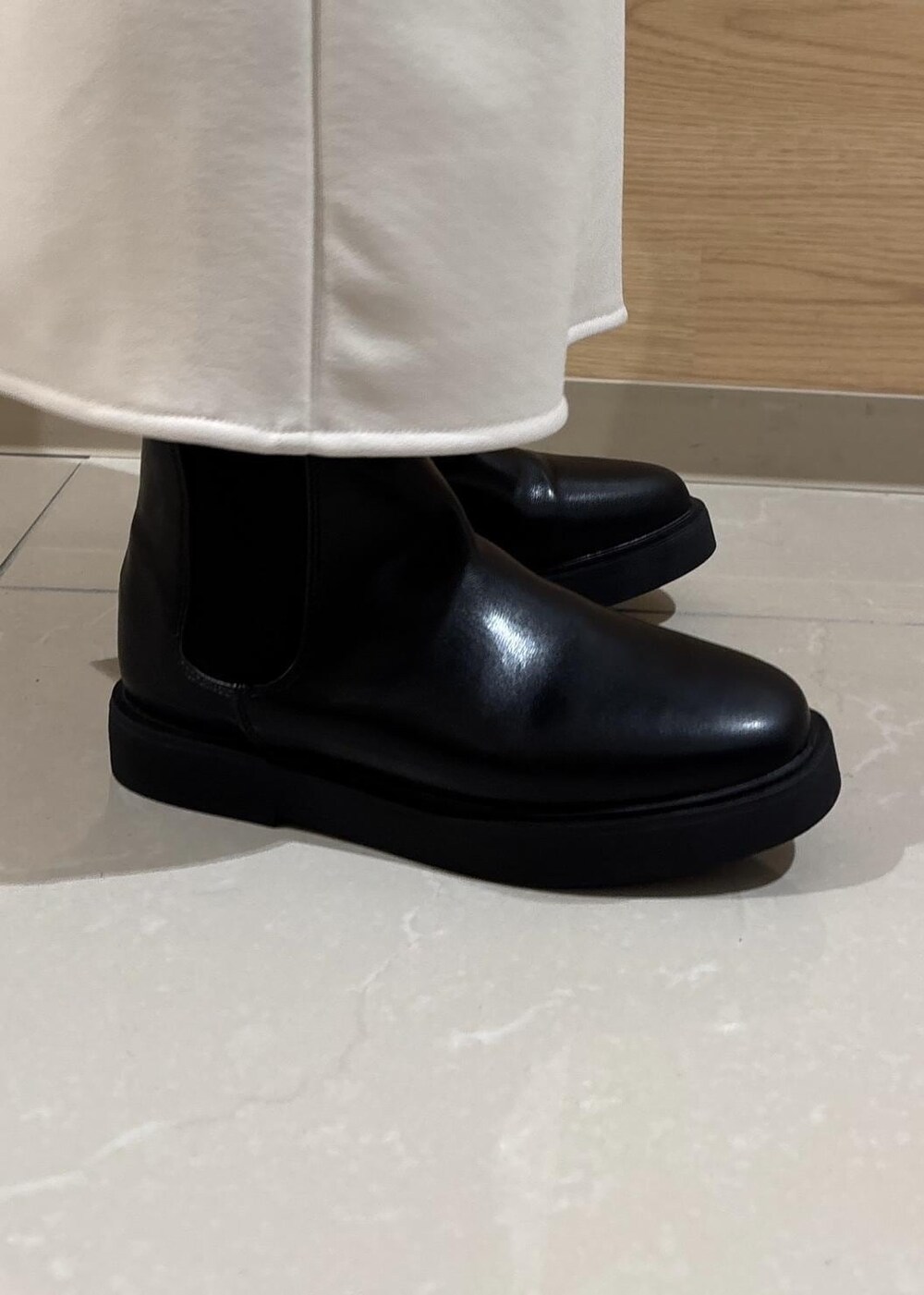 ベージュ系のスカート、ブルー系のニット/セーター、ブラック系のブーツを着用したレディースの冬コーディネートの9枚目の写真