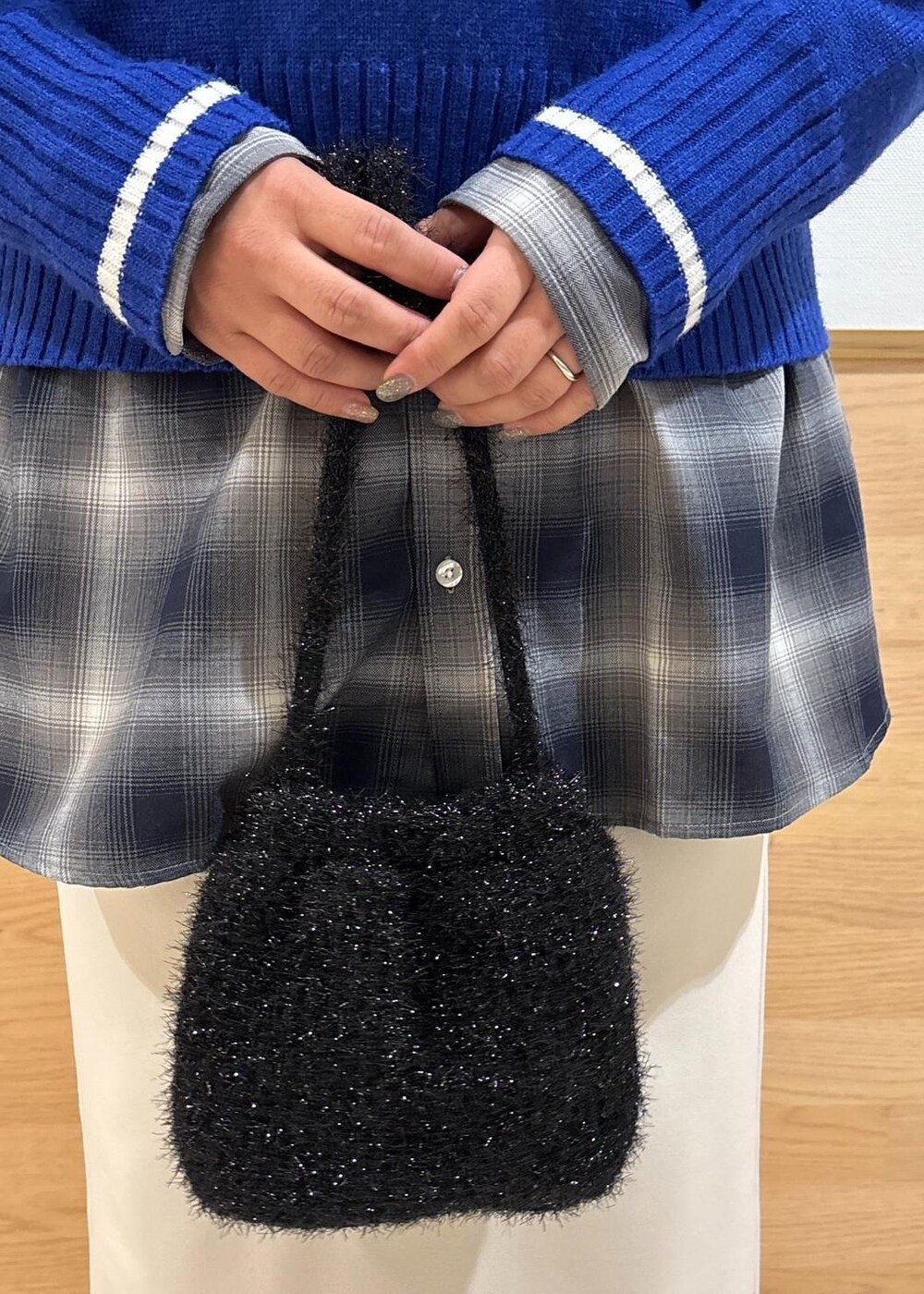 ベージュ系のスカート、ブルー系のニット/セーター、ブラック系のブーツを着用したレディースの冬コーディネートの8枚目の写真